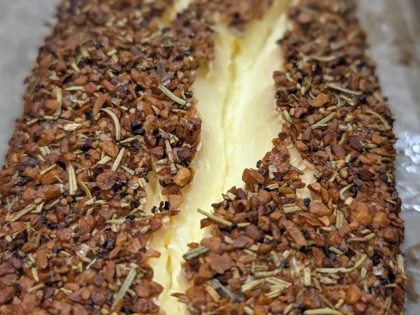 Smoked cream cheese in baking pan seasoned and ready for the oven or smoker